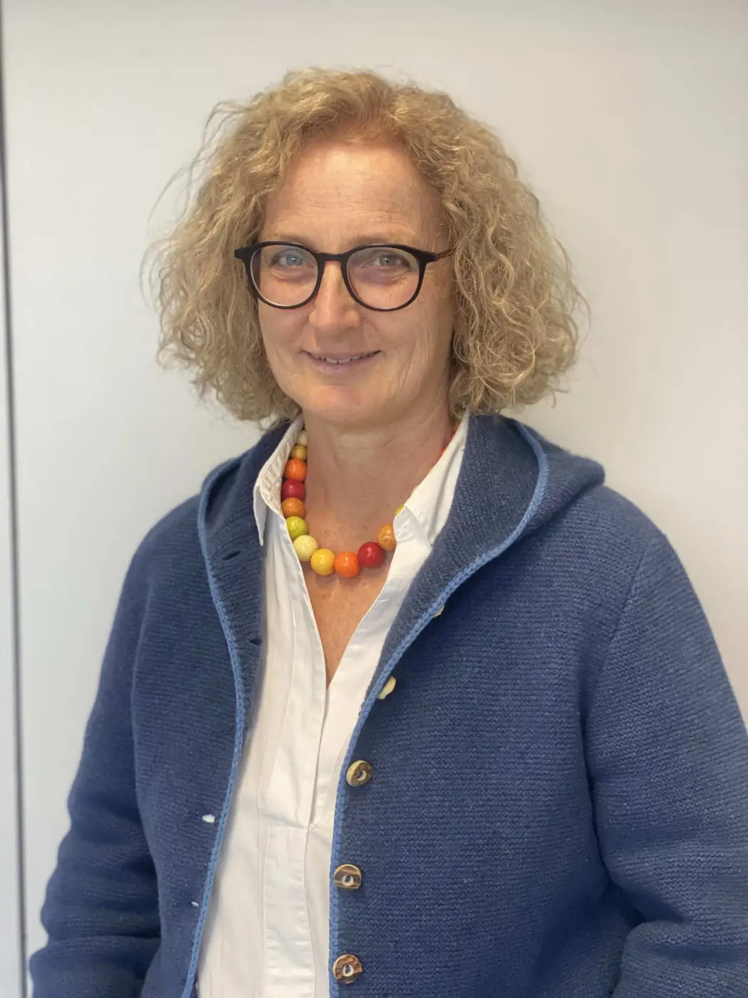 Porträt von Dorothea Obeser, StDin, Schulpsychologin der Städtischen Berufsschule. Sie trägt eine Brille, eine bunte Kette und eine dunkelblaue Strickjacke und ist die Ansprechpartnerin für Krisen, Lerncoaching und Schulleistungsprobleme im Sozialforum.