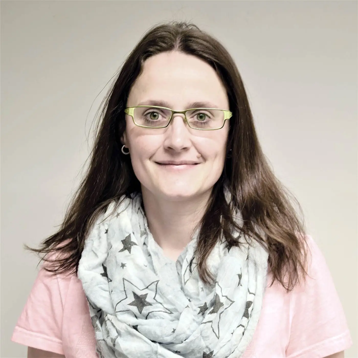 Porträt von Anja Huber, OStRin, Verbindungslehrkraft der Städtischen Berufsschule (MFA, PKA, TFA). Sie lächelt in die Kamera, trägt eine helle Brille und einen Schal mit Sternenmuster und ist Ansprechpartnerin für Anliegen der Schüler.