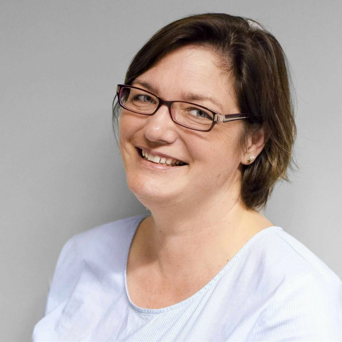 Petra Minkus, OStDin, Schulleiterin der Berufsschule, vor einem grauen Hintergrund.